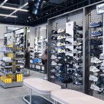 Ściana z butami sportowymi i najnowszymi modelami sneakersów wewnątrz sklepu JD Sports.