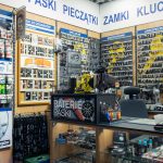 Stanowisko obsługi klienta w punkcie Mister Minit w Galaxy, otoczone ekspozycją kluczy i akcesoriów skórzanych.