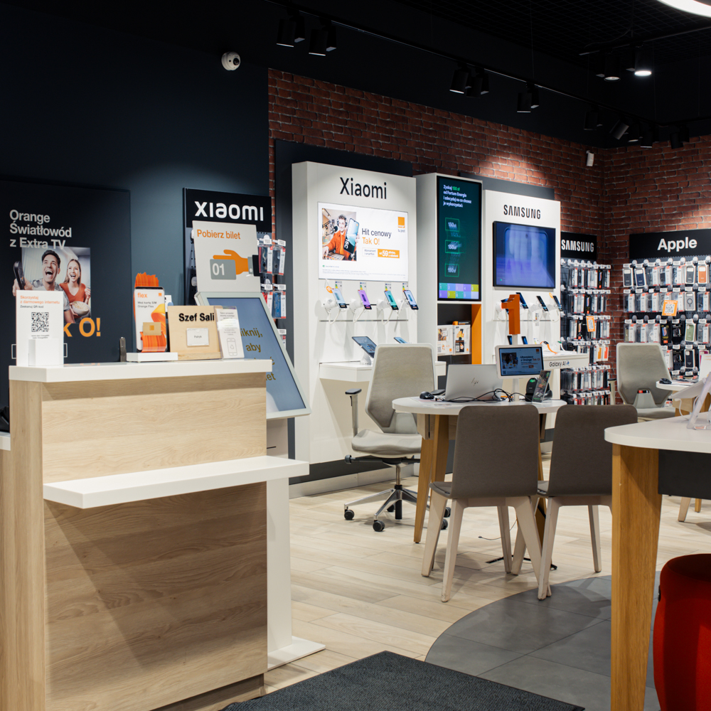 Stanowiska obsługi klienta w salonie Orange w Galaxy, gdzie doradcy pomagają w wyborze ofert i usług.