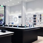 Przestronne wnętrze salonu Samsung w Szczecinie z najnowszymi telefonami wyeksponowanymi na podestach oraz akcesoriami na ścianach.