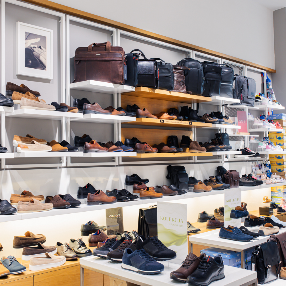 Ekspozycja obuwia męskiego w salonie Wojas w Centrum Galaxy; skórzane półbuty, trzewiki i sneakersy na regałach ściennych oraz nowoczesnych standach.