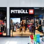 Wejście do sklepu PitBull w Galaxy, białe logo na czarnym tle.