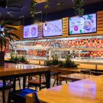 Wnętrze restauracji Marche w Galaxy z widoczną strefą bufetową i stolikami dla gości.