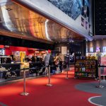 Nowoczesna strefa kasowa i snack bar w Multikinie w Centrum Galaxy z widocznymi ekranami repertuaru w tle.