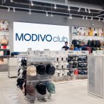 Nowoczesna, minimalistyczna lada kasowa w salonie Worldbox w Centrum Galaxy, z charakterystycznym brandingiem i technicznym oświetleniem.