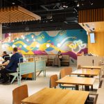 Perspektywa na salę jadalną restauracji Popeyes w Galaxy, pokazująca wygodne miejsca do siedzenia i unikalny design wnętrza.