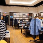 Stylowe wnętrze salonu Tommy Hilfiger w Szczecinie, prezentujące kolekcje ubrań, akcesoriów i obuwia w przestronnej aranżacji.