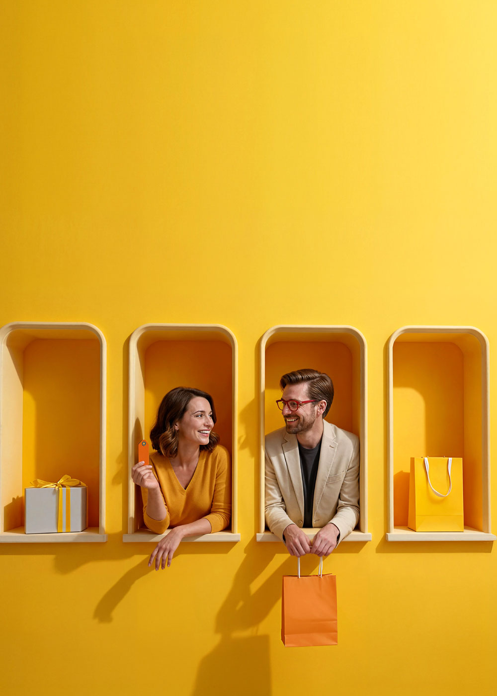 Kobieta z kartą płatniczą i mężczyzna z torbą zakupową wychylają się z dekoracyjnych żółtych wnęk; po bokach znajdują się torba zakupowa i pudełko prezentowe.