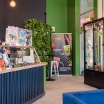 Zdjęcie przedstawia wnętrze salonu Bubble Joy, widać na nim wejście do kawiarni i baner przedstawiający najnowsze pozycje w menu.