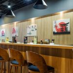 Wysokie hokeery i minimalistyczny blat przy ścianie w restauracji Unagi Sushi w Szczecinie, idealne na szybki lunch.