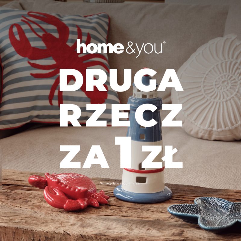 Dekoracje marynistyczne home&you: poduszka z homarem i latarnia morska na drewnianym stole. Informacja o promocji Druga rzecz za 1 zł.
