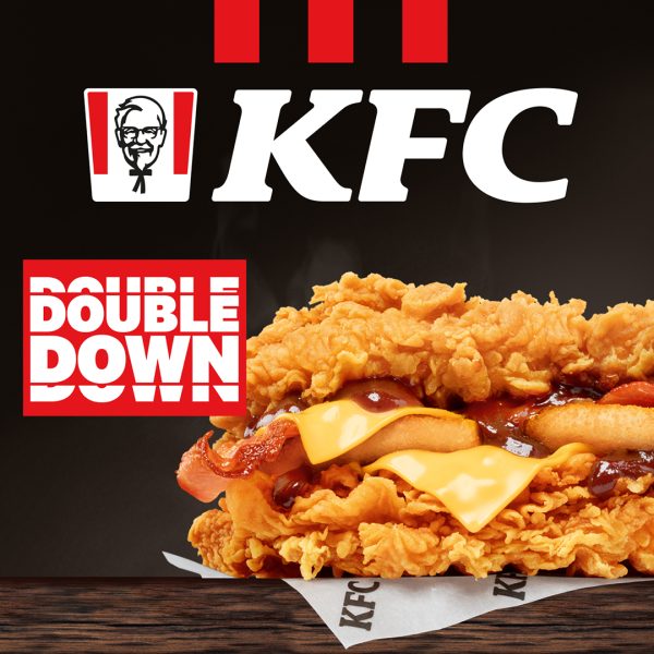 Soczysta kanapka Double Down z KFC z bekonem i serem zamiast bułki, widoczna na ciemnym tle.