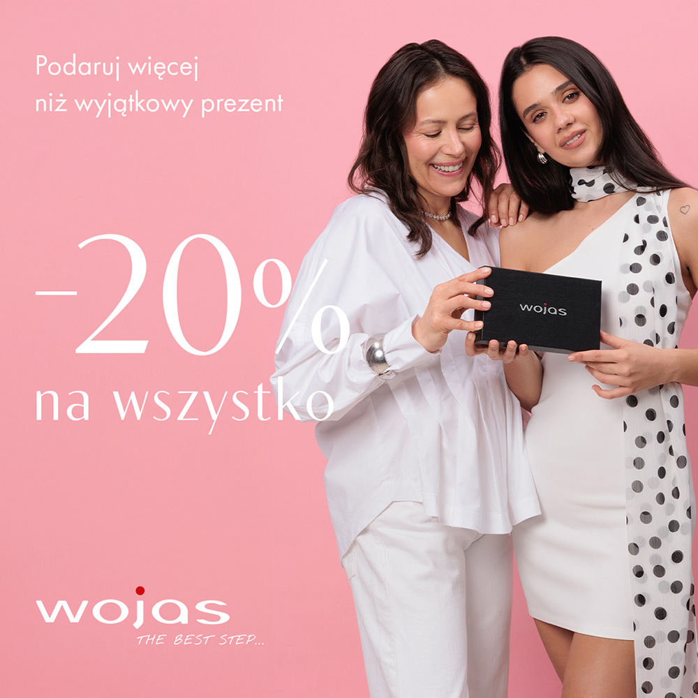Grafika reklamowa marki Wojas przedstawia uśmiechniętą kobietę w jasnym garniturze, która trzyma elegancką torebkę i pozuje w otoczeniu różowych oraz białych kwiatów. Po lewej stronie umieszczono duże napisy „Dzień Mamy”, informację o rabacie 20% na cały asortyment oraz logotyp marki w lewym górnym rogu.