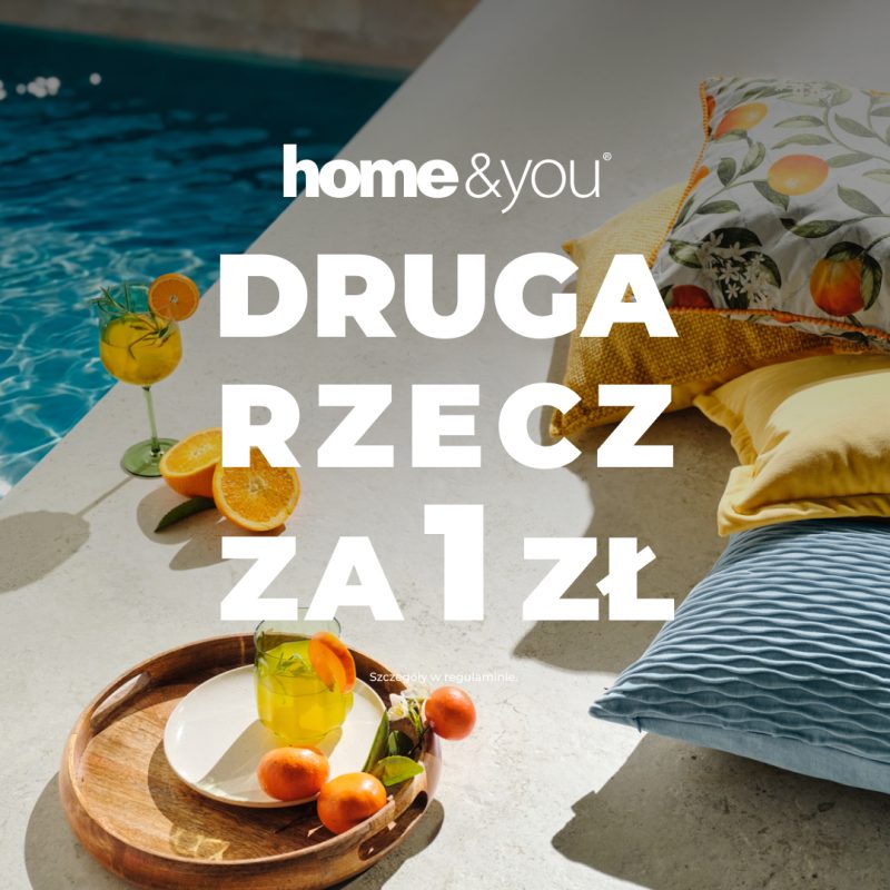 Promocyjna grafika home&you nawiązująca do wakacyjnego wypoczynku. Na zdjęciu widoczne są dekoracyjne poduszki, drewniana taca z napojem i owocami oraz basen w tle. Centralnie umieszczono komunikat o promocji „Druga rzecz za 1 zł”.