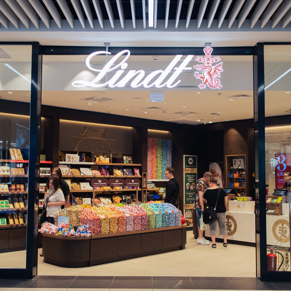 Wejście do salonu Lindt w Galerii Galaxy w Szczecinie. Widać regały pełne cukierków i czekolady.