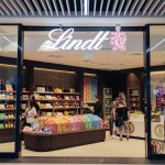 Wejście do salonu Lindt w Galerii Galaxy w Szczecinie. Widać regały pełne cukierków i czekolady.
