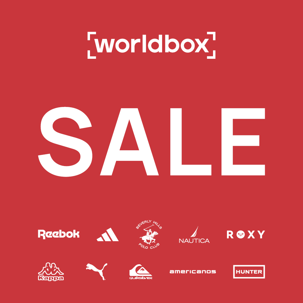 Grafika reklamowa marki Worldbox przedstawia duże, białe hasło „SALE” umieszczone w centralnej części na jednolitym, czerwonym tle. W górnej części widnieje logo sklepu, natomiast na dole rozmieszczono mniejsze logotypy popularnych marek streetwearowych i sportowych, takich jak Reebok, Adidas czy Puma.