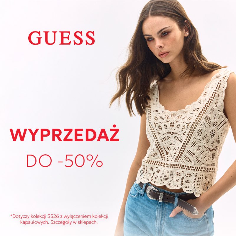 Grafika promocyjna marki GUESS informująca o wyprzedaży do -50%, przedstawiająca modelkę w koronkowym topie i jeansach na jasnym tle.