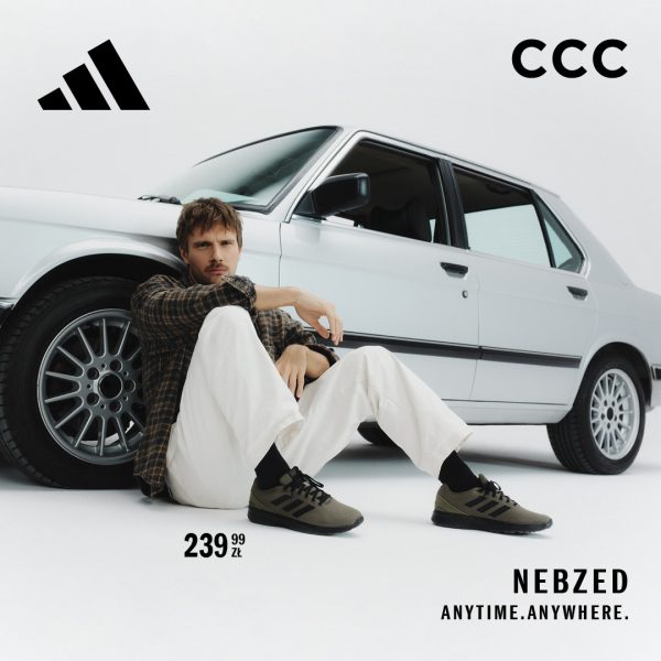 Wersja krótka (rekomendowana pod alt tekst): Reklama butów Adidas Nebzed w sklepie CCC. Mężczyzna w oliwkowych sneakersach, jasnych spodniach i koszuli w kratę siedzi oparty o przednie koło srebrnego, klasycznego samochodu. W rogach widoczne są logotypy Adidas i CCC, cena 239,99 zł oraz hasło „NEBZED. ANYTIME. ANYWHERE.”.