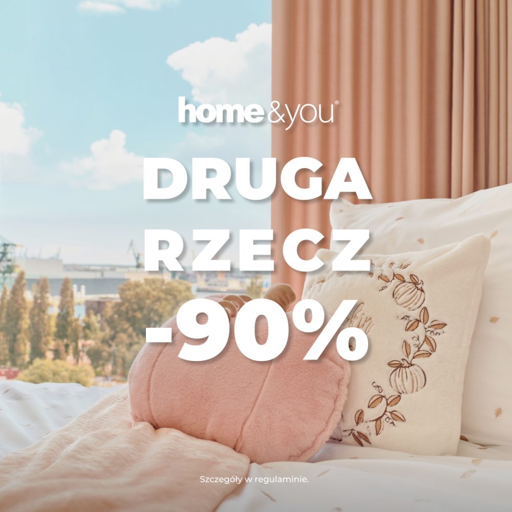 Kwadratowa grafika promocyjna marki home&you. Przedstawia przytulny kadr sypialni z łóżkiem usłanym białą pościelą z małym wzorem, różowym kocem oraz ozdobnymi poduszkami w kształcie dyni i z haftem. Za łóżkiem widoczne jest okno z widokiem na panoramę miasta oraz różowa zasłona. Na środku umieszczono białe logo home&you oraz duży biały napis DRUGA RZECZ -90%. Na dole drobny tekst Szczegóły w regulaminie.