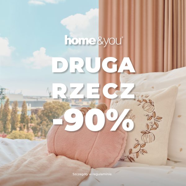 Kwadratowa grafika promocyjna marki home&you. Przedstawia przytulny kadr sypialni z łóżkiem usłanym białą pościelą z małym wzorem, różowym kocem oraz ozdobnymi poduszkami w kształcie dyni i z haftem. Za łóżkiem widoczne jest okno z widokiem na panoramę miasta oraz różowa zasłona. Na środku umieszczono białe logo home&you oraz duży biały napis DRUGA RZECZ -90%. Na dole drobny tekst Szczegóły w regulaminie.