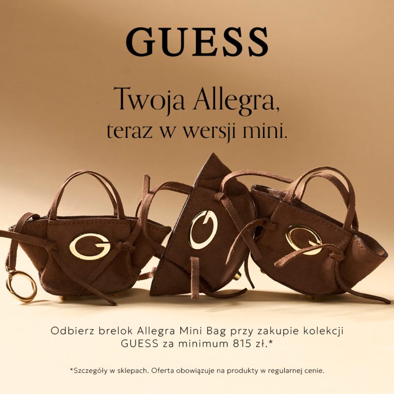 Kwadratowa grafika promocyjna marki GUESS na beżowym tle. Na samej górze widnieje czarny napis GUESS oraz Twoja Allegra, teraz w wersji mini. W centralnej części zaprezentowano trzy zamszowe breloki w kształcie małych brązowych torebek ze złotym logo w kształcie litery G i złotym kółkiem na klucze. Na dole umieszczono czarny napis Odbierz brelok Allegra Mini Bag przy zakupie kolekcji GUESS za minimum 815 zł oraz drobną adnotację o szczegółach w sklepach.
