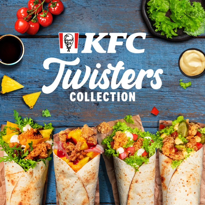 Grafika promocyjna restauracji KFC przedstawiająca kolekcję „Twisters Collection”. Na niebieskim, drewnianym stole wyeksponowano cztery różne tortille typu twister wypełnione chrupiącymi kawałkami kurczaka i świeżymi składnikami, w otoczeniu pomidorków koktajlowych, sałaty oraz miseczek z sosami. W centralnej części widnieje logo KFC oraz napis „Twisters COLLECTION”.