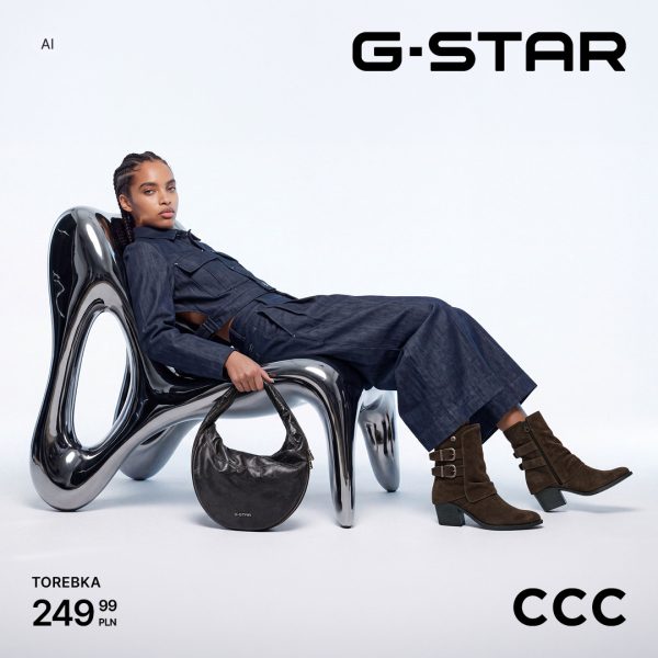 Modelka w ciemnym komplecie denimowym oparta o designerski fotel, prezentująca pojemną czarną torebkę G-Star za 249,99 zł i zamszowe buty w salonie CCC w CH Galaxy Szczecin